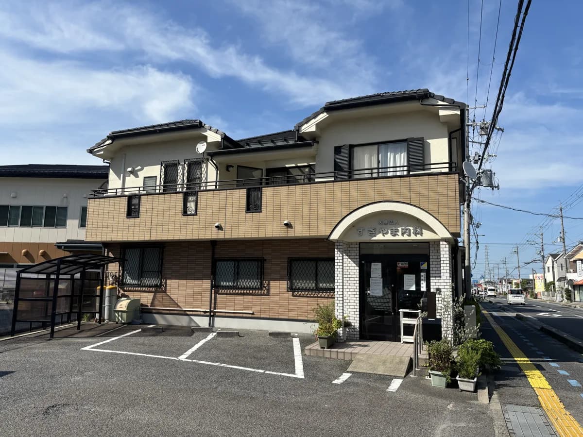 すぎやま内科の外観と駐車場 ― 医院の前と奥側に駐車場あり